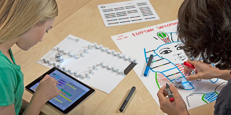 Two kids playing with Ozobot Evo