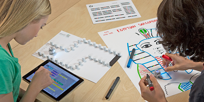 Two kids playing with Ozobot Evo