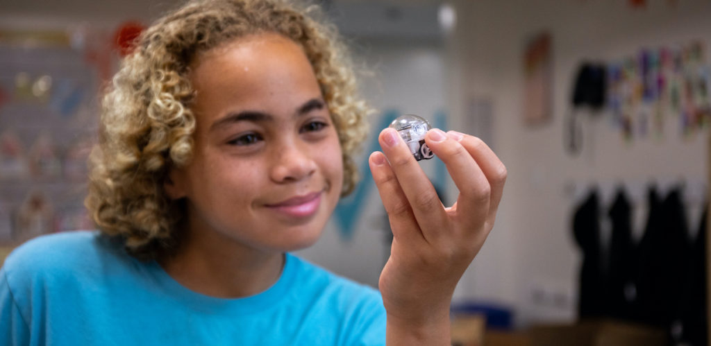 National Robotics Week 2024: smiling student holding Evo programmable robot