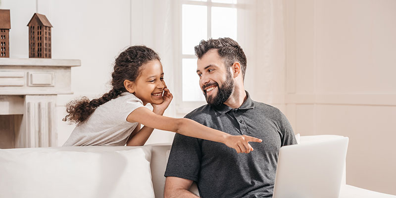Father and daughter learning to code on a laptop