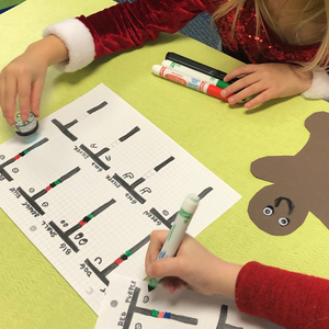A picture of students participating in Creating a Gingerbread Person Using Attribute STEAM activity by Ozobot